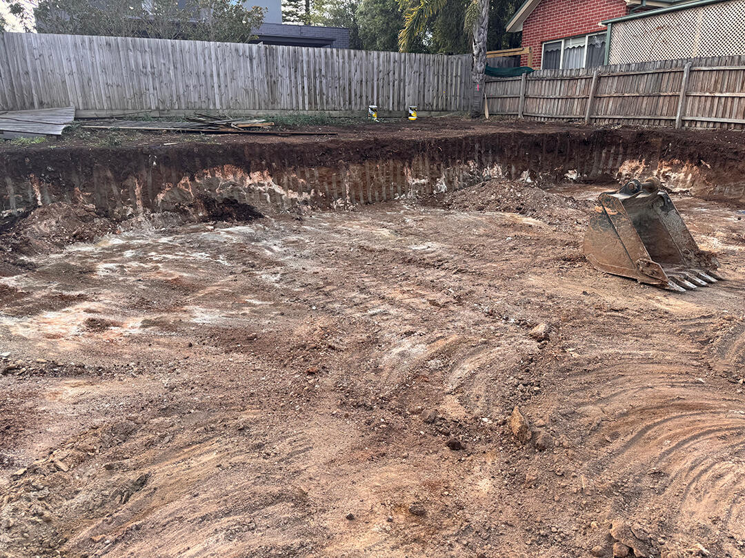 Site Cuts Melbourne – Excavator Levelling Ground for Construction Excavator performing site cuts in Melbourne, levelling the ground for a construction-ready site.